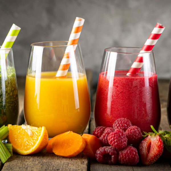 Selection of colorful smoothies and ingredients in glasses, rustic background